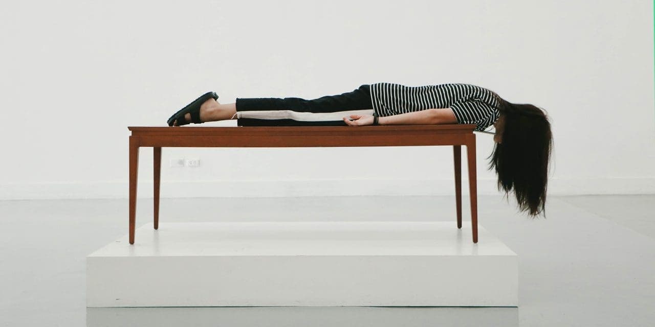 a woman lying face forward on the table with her hair hanging down